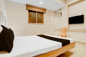 瓜廖尔Hotel O Jiwaji Chowk Lashkar的一间带床和窗户的白色卧室