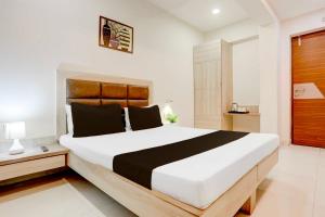 瓜廖尔Hotel O Jiwaji Chowk Lashkar的卧室配有一张白色和黑色的大床。 更多10张照片