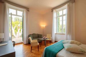 sypialnia z łóżkiem, stołem i oknami w obiekcie Relais Villa Sant'Isidoro w mieście Colbuccaro +37 zdjęć
