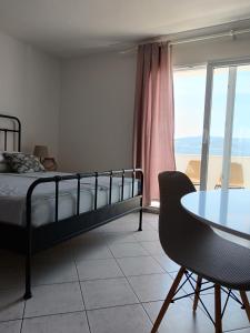 a bedroom with a bed and a table and a table and chairs at Apartmani More Komarna in Komarna