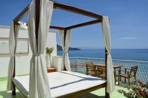 - un lit sur un balcon avec vue sur l'océan dans l'établissement Mediterraneo Guesthouse, à Giardini Naxos