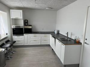 a kitchen with white cabinets and a sink at Thistedvej 85C, Room 3 in Nørresundby