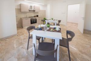 a kitchen with a white table and chairs in a room at Il Risveglio del Cavaliere Casa Vacanza in Gioia dei Marsi