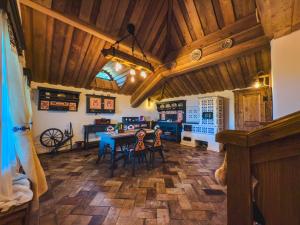 a dining room with wooden ceilings and a table and chairs at Căsuță tradițională cu ciubăr și saună în Bran - Casa de la Nuci in Sohodol