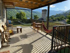 a porch with a hammock and a view of mountains at Bombora in Mestia