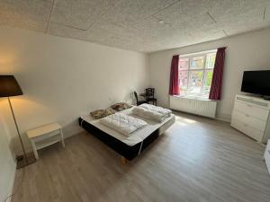 a bedroom with a bed and a television in it at Thistedvej 85C, Room 4 in Nørresundby