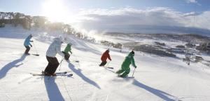 people riding skis down a snow covered slope at Kookaburra Lodge in Jindabyne