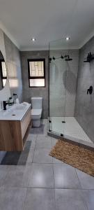 a bathroom with a shower and a sink and a toilet at Nicola's Studio Apartment Knysna by First Private Stays in Knysna +15 photos