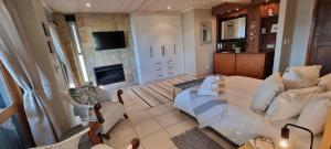 a living room with a bed and a fireplace at Nicola's Studio Apartment Knysna by First Private Stays in Knysna