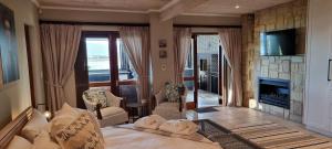 a living room with a bed and a fireplace at Nicola's Studio Apartment Knysna by First Private Stays in Knysna
