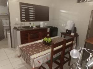 a kitchen with a table and a table and a television at Casa de Nylva Beach Pipa in Pipa