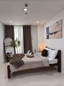 a bedroom with a large bed with a large window at 1BR with Pool at One Pontefino Tower, Batangas City in Batangas City