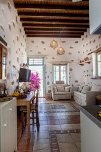 a kitchen and living room with a table and a couch at Castro Nido in Astypalaia Town