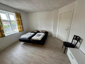 a bedroom with a bed and a chair in it at Thistedvej 85C, Room 5 in Nørresundby