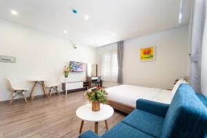 a hotel room with a bed and a blue couch at Jade house Nguyễn Thị Minh Khai in Ho Chi Minh City