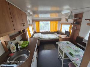 a small kitchen with a sink and a bedroom at Dom Bursztynek - holender in Junoszyno