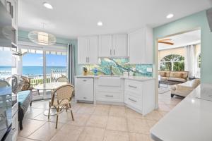 une cuisine avec des armoires blanches et une vue sur l'océan dans l'établissement Ark condo, à Captiva 33 autres photos