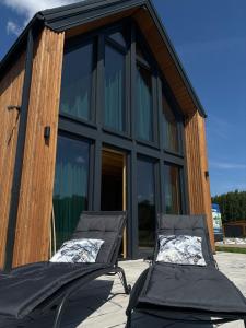 two chairs on a patio in front of a building at Villa Jungle House - Mazury in Liwa