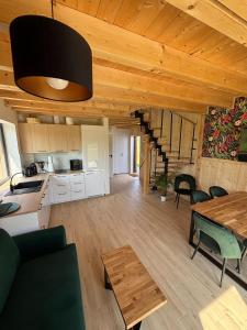 a kitchen and living room with a wooden ceiling at Villa Jungle House - Mazury in Liwa