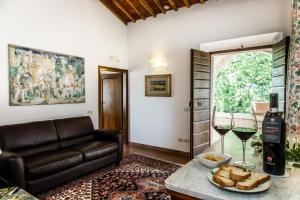 a living room with a couch and a table with wine glasses at Villa Acquaviva Wine Resort in Montemerano