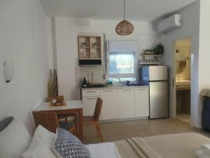a small kitchen with a table and a refrigerator at Athos Mare Holiday Studios in Pefkochori