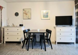 a dining room with a table and a tv at Ferienwohnung Kajüte C 17 in Burhave
