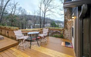een houten terras met stoelen en een tafel erop bij Karens Cozy Cottage in Gatlinburg