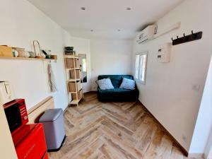 a living room with a green couch and wooden floors at Appartement, terrasse plage, Mmm in Antibes