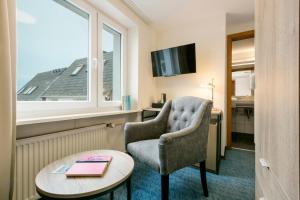 a room with a chair and a table and a window at Hotel auf den Hummerklippen in Helgoland