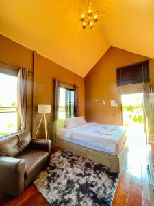 una camera da letto con un letto, un divano e finestre di Bergen Resort Khon Kaen a Khon Kaen
