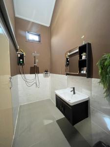un bagno con lavandino e specchio di Bergen Resort Khon Kaen a Khon Kaen Altre 6 foto