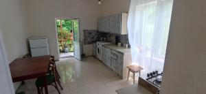 a kitchen with a counter and a table and a window at გიოს ქოხი in Nak'alak'evi +34 photos