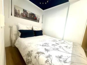 a bedroom with a white bed with a black and white comforter at Scandi Apartment with Terrace and Parking in Karlsruhe