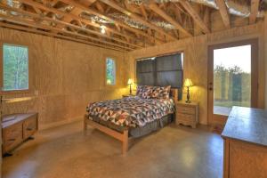 a bedroom with a bed and a desk and windows at Sweet Seclusion Firepit king suite serene outdoor spaces in Mineral Bluff