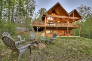 a cabin in the woods with chairs and a campfire at Sweet Seclusion Firepit king suite serene outdoor spaces in Mineral Bluff
