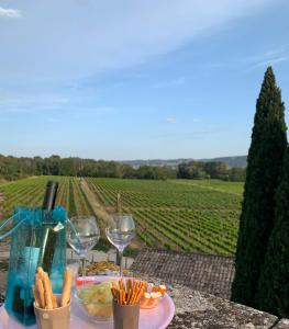 - une table avec des verres à vin et une assiette de nourriture dans l'établissement Le gîte de Figon, à Laudun-l'Ardoise 3 autres photos