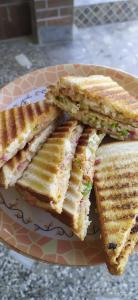 a plate with four grilled sandwiches on it at Gaani Homestay Uttarkashi in Uttarkāshi