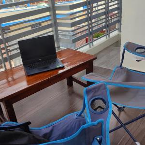 a laptop computer sitting on a wooden table with a chair at Gaani Homestay Uttarkashi in Uttarkāshi