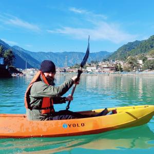 a man sitting in a kayak in the water at Gaani Homestay Uttarkashi in Uttarkāshi