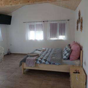 Bett in einem Zimmer mit zwei Fenstern in der Unterkunft Casa Diana Tocile in Sadu + 7 Fotos