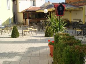 a patio with chairs and tables and a restaurant at Konak Požarevac in Požarevac