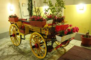 a yellow carriage filled with potted plants and flowers at Konak Požarevac in Požarevac +26 photos