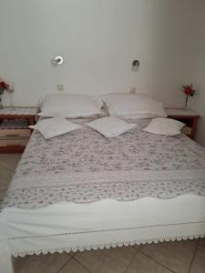 a large bed with white sheets and pillows on it at Small Nature house Teodora in Novalja +17 photos