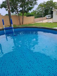 a large swimming pool with blue water in a yard at Small Nature house Teodora in Novalja