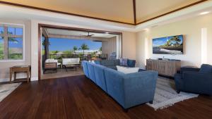 Una sala de estar con sofás azules y una mesa. en SWEET HEAVEN Upscale 4BR KaMilo Home with Bikes and Golf Clubs, en Waikoloa