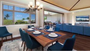 Un comedor con una mesa y sillas azules. en SWEET HEAVEN Upscale 4BR KaMilo Home with Bikes and Golf Clubs, en Waikoloa