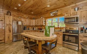 eine Küche mit Holzschränken und einem Tisch mit Stühlen in der Unterkunft Beartastic Mountain View Lodge in Gatlinburg