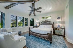 安娜玛丽亚Tern Key - New Luxury Canal Front Home with Pool Spa Dock Close to Bean Point Pine Ave的带床和吊扇的卧室 更多29张照片