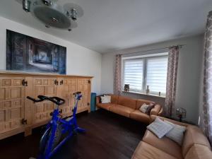 a blue bike in a living room with a couch at Centrally located spacious flat close to Rhine in Bonn