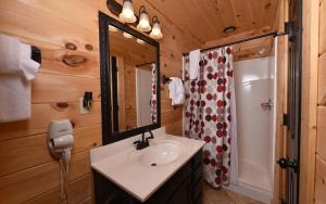 een badkamer met een wastafel en een spiegel bij Mountain Romance in Sevierville +11 foto's